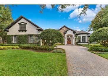 Charming one-story home with lush landscaping and a paved driveway at 6761 Valhalla Way, Windermere, FL 34786