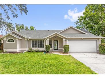 Charming single-story home featuring a well-manicured lawn, attached two car garage, and a decorative front door at 248 Country Landing Blvd, Apopka, FL 32703