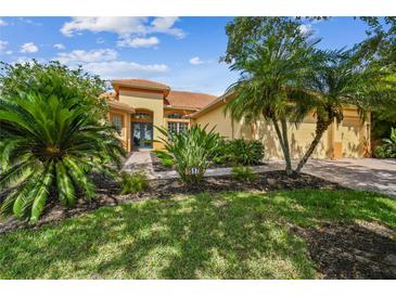 Inviting home with a barrel tile roof, lush landscaping, and brick paver walkway at 517 Milano Rd, Poinciana, FL 34759