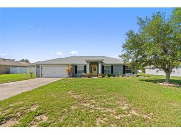 Charming single-story home featuring a well-manicured lawn, attached garage and inviting yellow front door at 6006 Country Walk Ln, Winter Haven, FL 33880