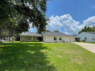 Charming single-story home with a well-manicured lawn and driveway leading to the attached garage at 7200 Green Pine Ct, Orlando, FL 32819