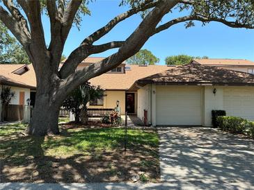 Charming townhome with a one-car garage and lush landscaping, including a large tree providing shade at 940 Fenton Ln # 8, Lakeland, FL 33809