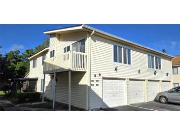 Inviting two-story condo featuring a private balcony and individual garages at 1024 Spring Meadow Dr, Kissimmee, FL 34741