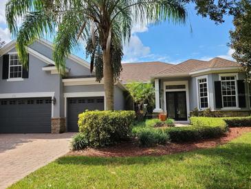 Charming home with a well-manicured lawn and a beautiful palm tree in the front yard at 1771 Lee Janzen Dr, Kissimmee, FL 34744