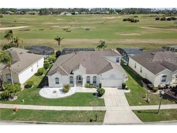 Aerial view of a home overlooking a golf course, featuring a well-manicured lawn at 520 Prestwick Dr, Davenport, FL 33897