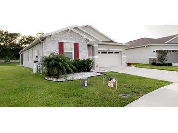 Charming single-Gathering home with stone accents, well-manicured lawn and red shutters at 5306 Meadow Song Dr, Okahumpka, FL 34762