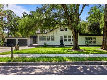 Charming two-story home with lush landscaping, mature trees, and a two car garage at 650 Main St, Altamonte Springs, FL 32701