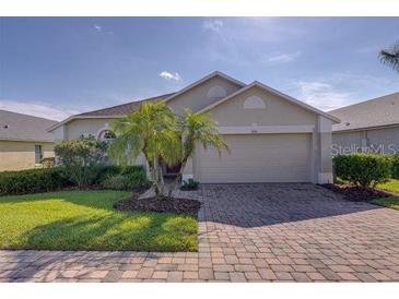 Charming single-story home with well-manicured lawn, lush landscaping, and a two-car garage at 926 Balmoral Dr, Davenport, FL 33896