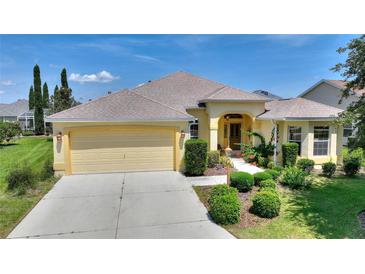 Charming single-story home featuring a two-car garage, well-manicured lawn, and inviting entryway at 1258 Donalds Pl, The Villages, FL 32162
