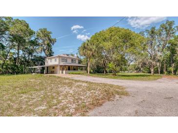 Charming two-story home with a long driveway and a covered parking area on a sunny day at 2652 N Woodland Blvd, Deland, FL 32720