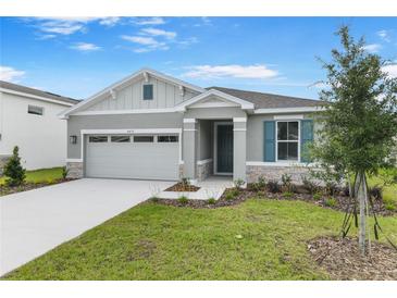 Charming single-story home featuring a manicured lawn, stone accents, and a two-car garage at 4071 Bannock Ave, Tavares, FL 32778