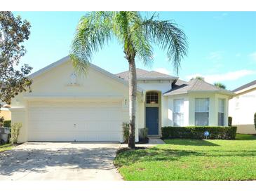 Inviting single-story home with a well-manicured lawn and a majestic palm tree in the front yard at 847 Orista Dr, Davenport, FL 33897