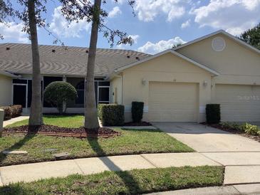 Charming villa with a well-maintained lawn, tidy landscaping, and an attached one-car garage at 88 Club Villas Ln, Kissimmee, FL 34744