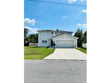 Charming two-story home with a well-manicured lawn and a two-car garage, located on a sunny street at 467 Martigues Drive, Kissimmee, FL 34759