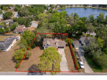 Lovely home with an expansive yard with mature trees, a long driveway, and a view of the lake at 120 W Minnehaha Ave Ave, Clermont, FL 34711
