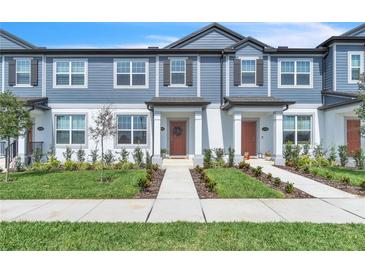 Charming townhome featuring a light blue exterior, well-manicured lawn, and inviting entryway at 12190 Plumpton Dr, Winter Garden, FL 34787