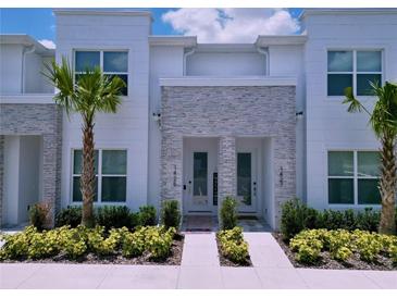 Inviting townhome entrance with manicured landscaping, stone accents, and a bright, modern facade at 1425 Serendipity Ln, Clermont, FL 34714