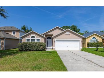 Charming single-story home with a well-manicured lawn, two-car garage, and inviting entryway at 265 Curtis Ave, Groveland, FL 34736