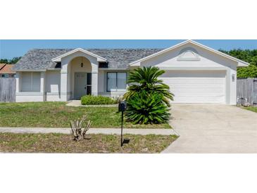 Charming single-story home with a well-maintained front yard, lush landscaping, and attached two-car garage at 408 Sandpiper Ridge Dr, Orlando, FL 32835