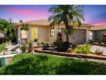 Charming home with a well-manicured lawn, vibrant landscaping, and a welcoming front exterior at 608 Grand Canal Dr, Poinciana, FL 34759