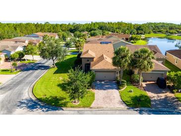 Beautiful single-story home featuring manicured lawns, mature trees, and a brick driveway at 803 Shady Canyon Way, Kissimmee, FL 34759