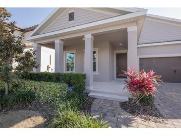 Inviting front porch with well-maintained landscaping and a brick walkway at 8607 Crescendo Ave, Windermere, FL 34786