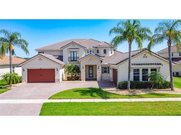 Stunning two-story home with lush landscaping, a paver driveway, and a barrel tile roof at 1211 Terralago Way, Kissimmee, FL 34746