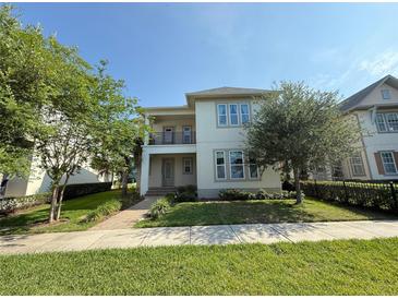 Charming two-story home featuring a balcony, a manicured lawn and lush landscaping at 13065 Gabor Ave, Orlando, FL 32827