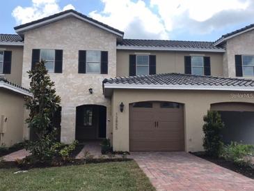 Charming townhome with an attached garage and well-manicured landscaping at 13885 Arclid St, Orlando, FL 32832