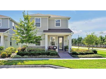 Charming two-story home with manicured landscaping and a welcoming front porch at 14389 Lanikai Beach Dr, Orlando, FL 32827
