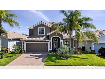 Beautiful two-story home with a tile roof, well-manicured lawn, and mature palm trees at 1470 Lake Side Ave, Davenport, FL 33837