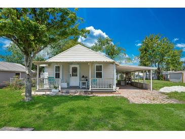 Charming single-story home with a well-manicured lawn, covered front porch, and a covered carport at 1626 Gar St, St Cloud, FL 34771