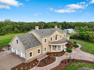 Elegant estate featuring a three-car garage, manicured landscaping, and a welcoming front entrance at 2851 Wagon Ct, St Cloud, FL 34772