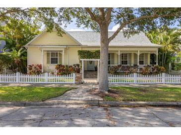 Charming yellow home with a white picket fence and lush landscaping at 3349 Schoolhouse Rd, Harmony, FL 34773