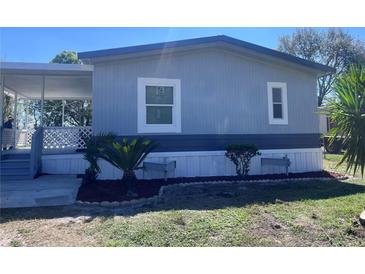 Charming single story home featuring a covered porch, complemented by fresh landscaping and healthy palm trees at 710 Whispering Pines Dr, Auburndale, FL 33823
