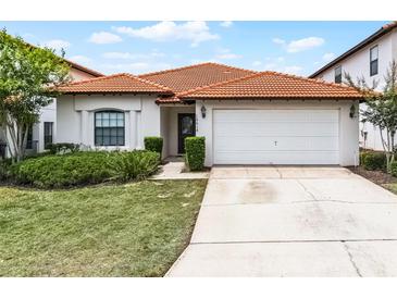 Charming single-story home showcasing a red tile roof, well-maintained lawn, and an attached two-car garage at 16614 Lazy Breeze Loop, Clermont, FL 34714