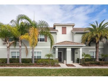 Charming townhome featuring well-maintained landscaping and a welcoming covered entrance at 4875 Clock Tower Dr, Kissimmee, FL 34746