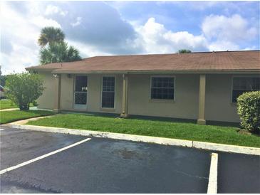 Charming single-story home with a cozy front porch, lush green lawn, and an inviting entrance at 1001 Plantation Dr # E1, Kissimmee, FL 34741