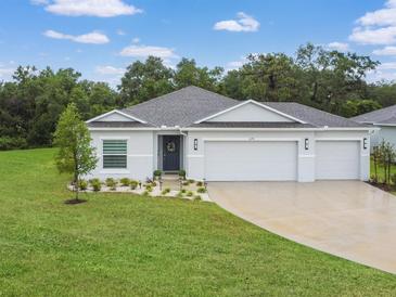 Beautiful home featuring a three-car garage, manicured lawn, and well-maintained landscaping, set in a lush, green neighborhood at 1278 Asher Mason Ave, Kissimmee, FL 34744