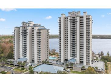Stunning view of two modern high-rise condos with multiple balconies and a lakeside pool at 13415 Blue Heron Beach Dr # 401, Orlando, FL 32821