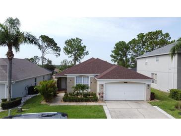 Charming single-story home featuring a well-manicured lawn, a two-car garage, and lush landscaping at 1428 Park Pl, Haines City, FL 33844
