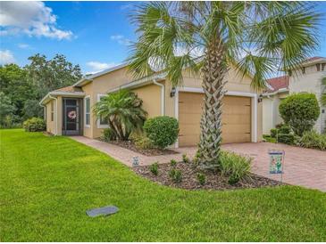Charming home featuring a well-manicured lawn, palm trees, and a delightful screened-in porch at 1447 Harbor Ridge Drive, Poinciana, FL 34759