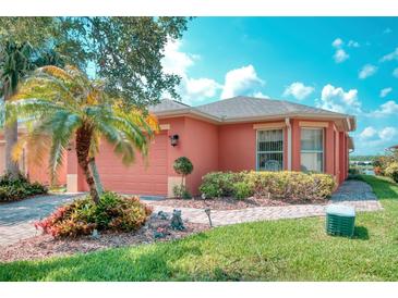 Charming single-story home with well-manicured landscaping, palm tree, and brick walkway at 233 Rialto Rd, Kissimmee, FL 34759