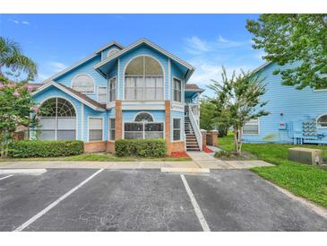 Charming blue two-story home featuring arched windows, brick accents and a cozy upstairs entrance at 2743 N Poinciana Blvd # 55, Kissimmee, FL 34746