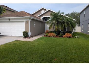 Charming home featuring a manicured front yard with a lovely garden and a two-car garage at 5921 Lake Champlain Dr, Orlando, FL 32829