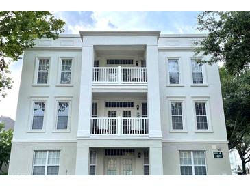 Stylish three-story condo building featuring white exterior and private balconies on the second and third floors at 1020 Siena Park W Blvd # 304, Kissimmee, FL 34747