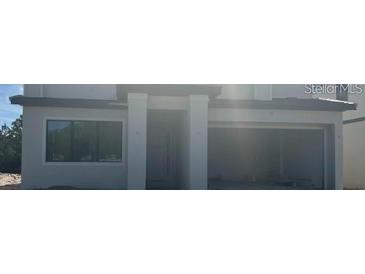 Modern home featuring a clean architectural design, covered entry, and attached two car garage at 1271 Butterfly, Davenport, FL 33837