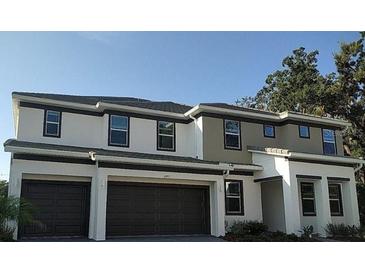 Two-story home featuring a two-car garage, neutral-toned facade, and a well-manicured lawn at 2373 Shanti Dr, Kissimmee, FL 34746