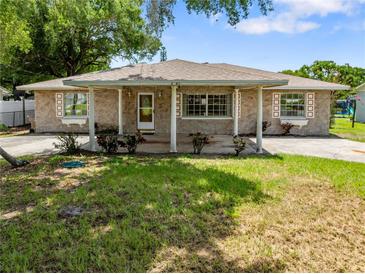 Charming single-story home featuring a covered front porch, stone facade, and well-maintained lawn at 2947 Larson St, Kissimmee, FL 34741