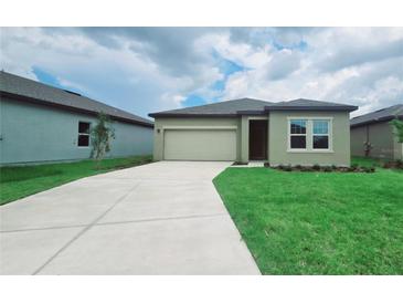 Charming one-story home featuring a two-car garage, well-manicured lawn, and inviting front entrance at 409 Conway Ave, St Cloud, FL 34771